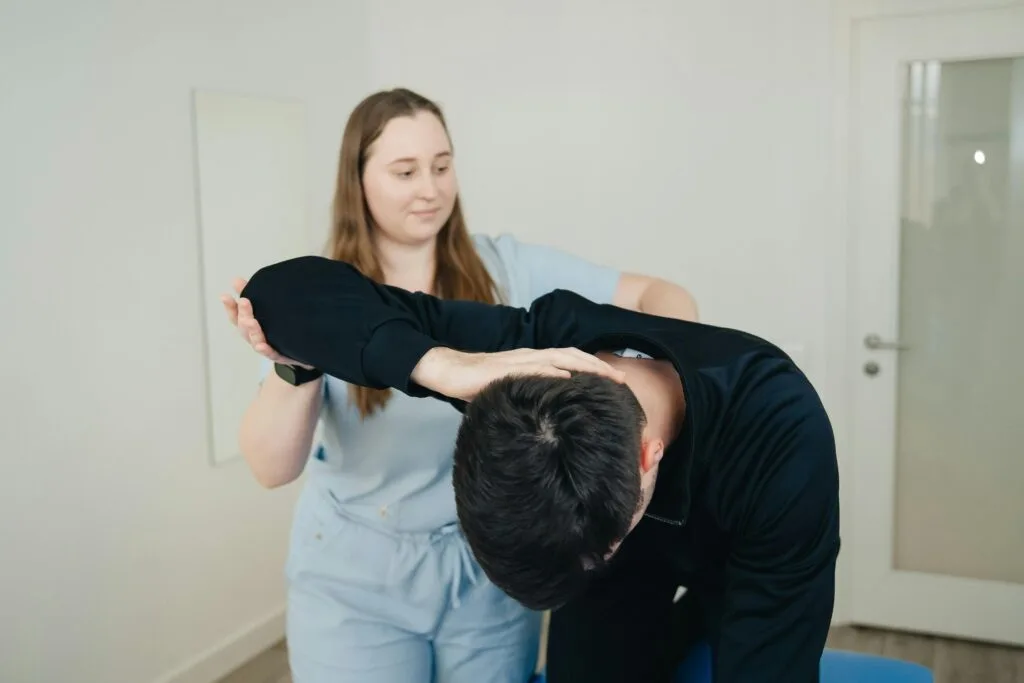 A StretchMaster physiotherapist aids a patient in a stretching exercise for rehabilitation.