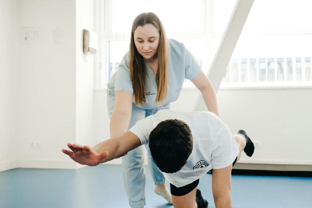 A StretchMaster physiotherapist assists a patient in stretching exercises indoors.