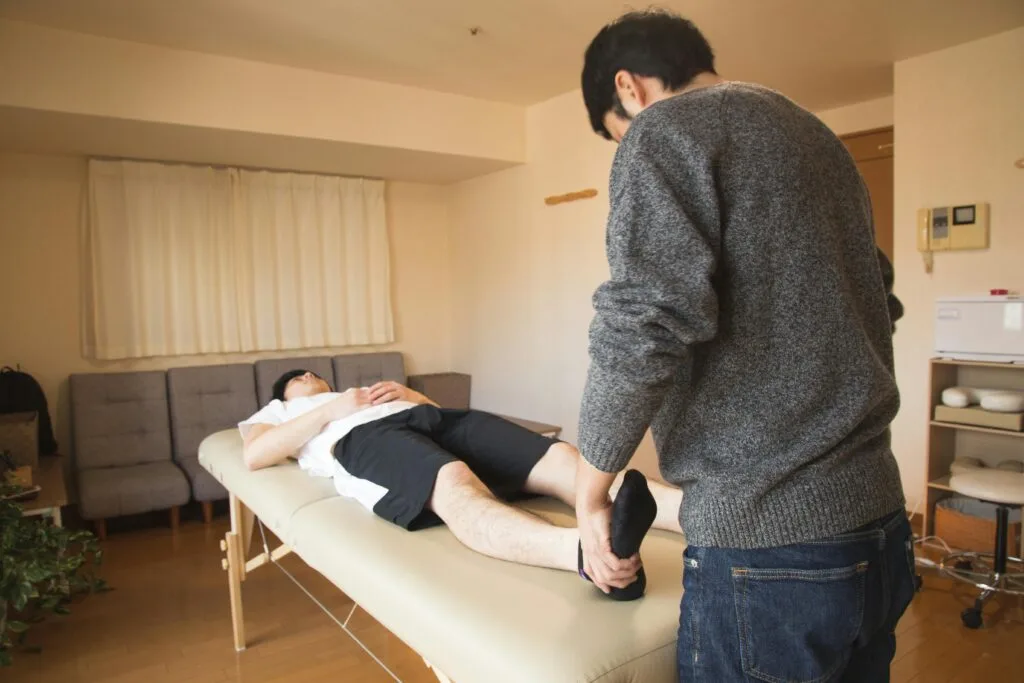 A StretchMasters physiotherapist provides therapy to a male patient in a comfortable indoor setting.