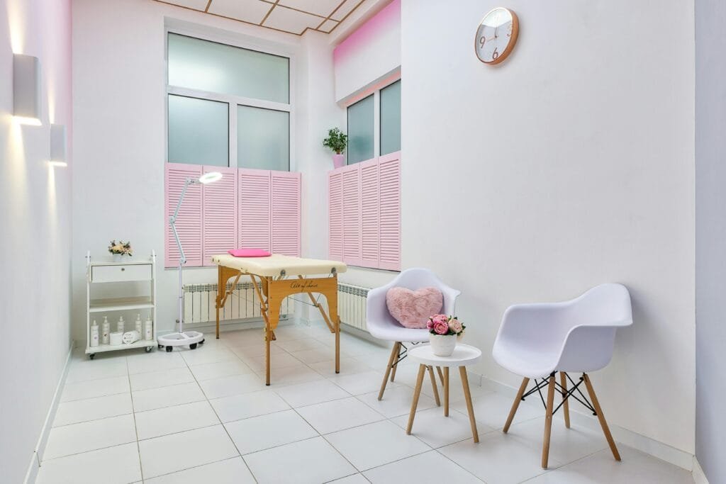 Interior of beauty salon with table for spa procedures and set of skincare products and flower decorations